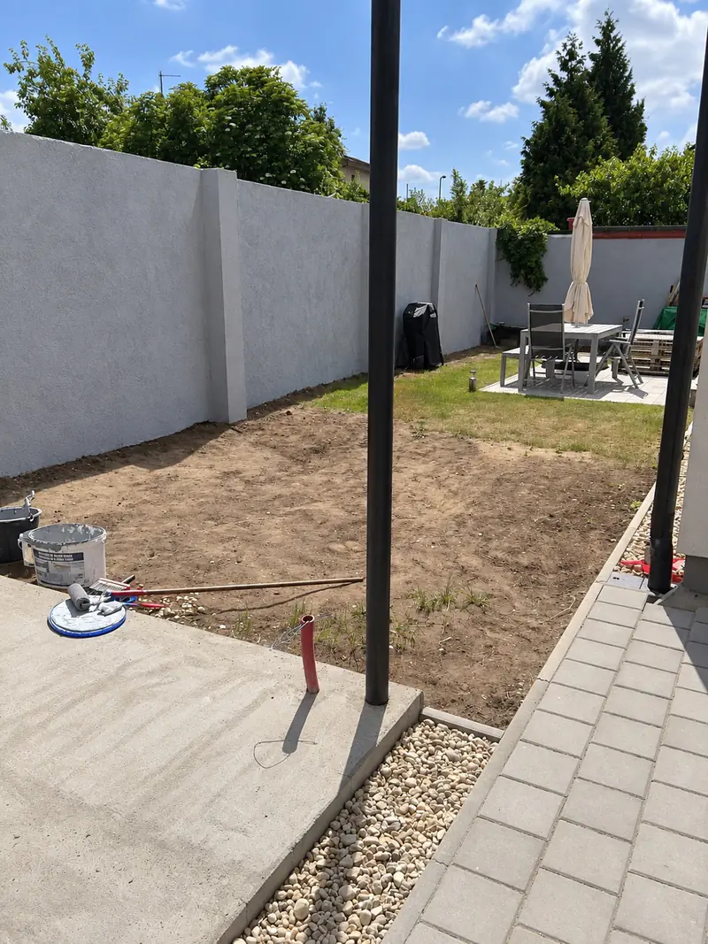 Nová omítnutá zahradní zeď a chodník z dlažby po rekonstrukci